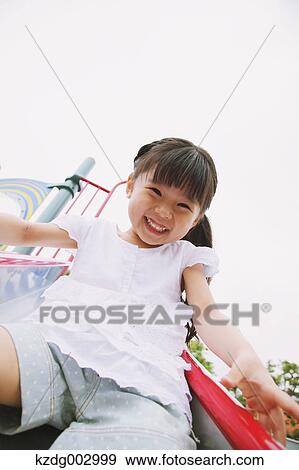 Young girl playing in the park View Large Photo Image Stock Photo - Young girl playing in the park. Fotosearch