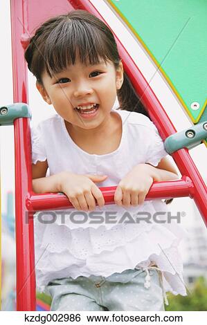 Young girl playing in the park View Large Photo Image Stock Photograph - Young girl playing in the park. Fotosearch