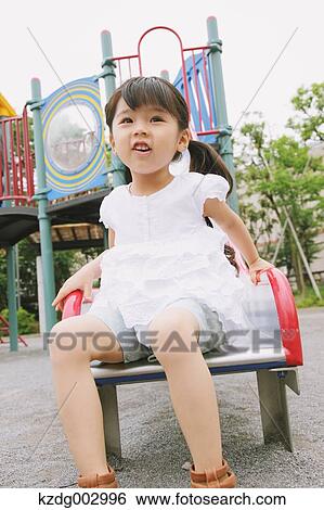 Stock Photograph - Young girl playing in the park. Fotosearch