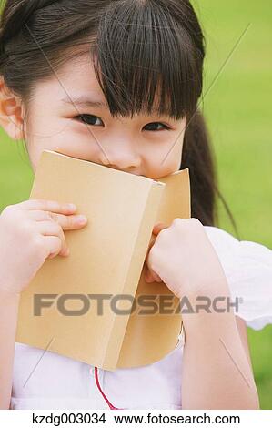 Young girl sitting with a book View Large Photo Image Picture - Young girl sitting with a book. Fotosearch