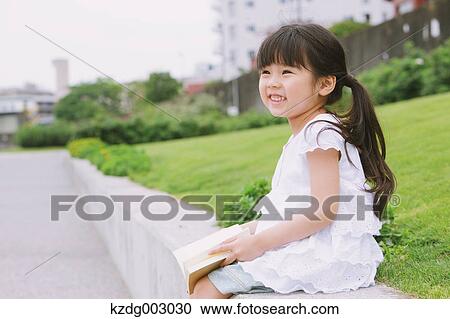 Young girl sitting with a book View Large Photo Image Stock Image - Young girl sitting with a book. Fotosearch