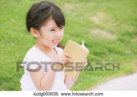 Stock Photography - Young girl sitting with a book. Fotosearch