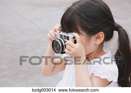 Picture - Young girl with camera. Fotosearch