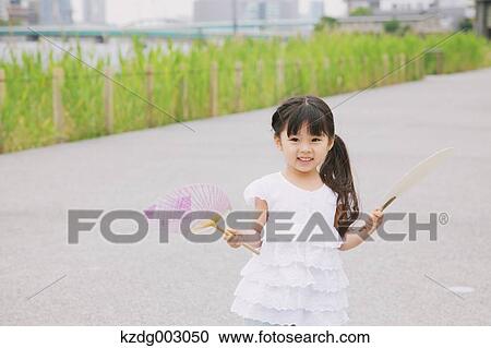 Young girl with paper fan View Large Photo Image Stock Image - Young girl with paper fan. Fotosearch