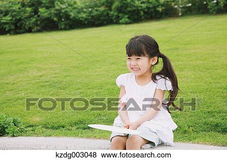 Young girl with paper fan View Large Photo Image Stock Photo - Young girl with paper fan. Fotosearch