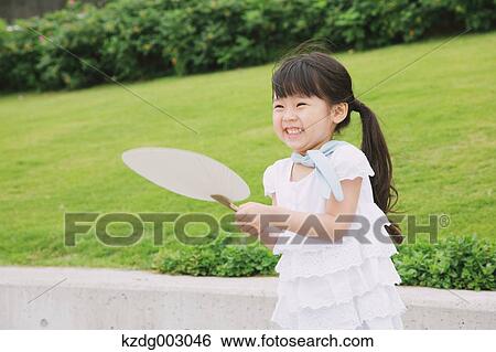 Stock Photograph - Young girl with paper fan. Fotosearch
