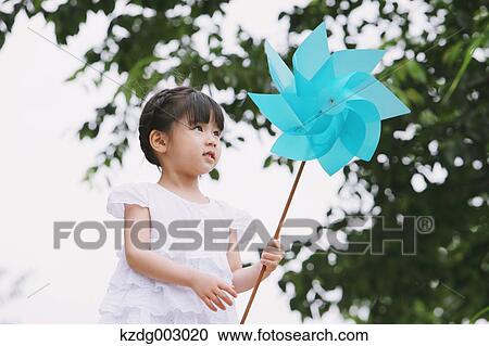 Stock Image - Young girl with pinwheel. Fotosearch