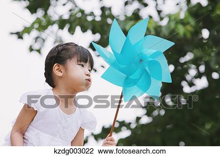 Stock Image - Young girl with pinwheel. Fotosearch