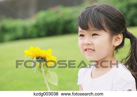 Stock Photo - Young girl with sunflower. Fotosearch