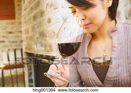 Young Japanese woman tasting wine in a fashionable bar View Large Photo Image Picture - Young Japanese woman tasting wine in a fashionable bar. Fotosearch