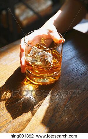 Stock Image - Young Japanese woman with glass of whiskey in a fashionable bar. Fotosearch