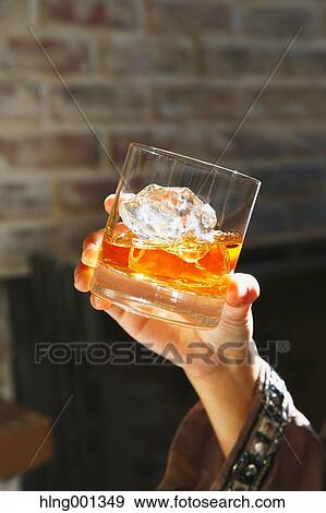 Stock Photo - Young Japanese woman with glass of whiskey in a fashionable bar. Fotosearch