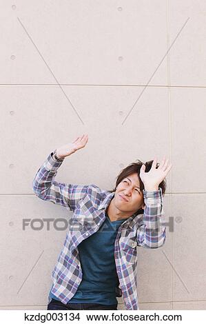 Young man hands on against a white wall View Large Photo Image Picture - Young man hands on against a white wall. Fotosearch