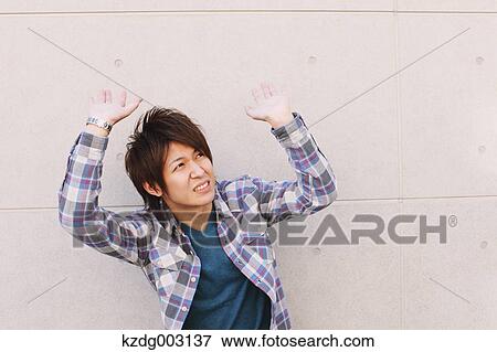 Young man hands on against a white wall View Large Photo Image Stock Photo - Young man hands on against a white wall. Fotosearch