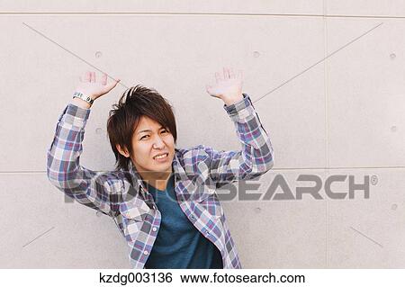 Stock Photograph - Young man hands on against a white wall. Fotosearch