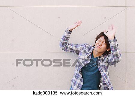 Stock Photography - Young man hands on against a white wall. Fotosearch