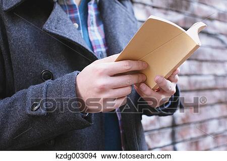 Picture - Young man holding a book. Fotosearch