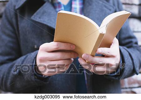 Stock Photography - Young man holding a book. Fotosearch