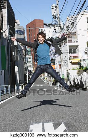 Young man jumping in an alley View Large Photo Image Stock Image - Young man jumping in an alley. Fotosearch