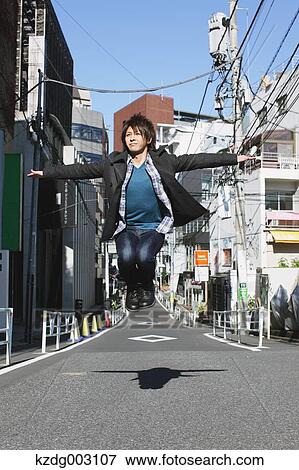 Young man jumping in an alley View Large Photo Image Stock Photo - Young man jumping in an alley. Fotosearch