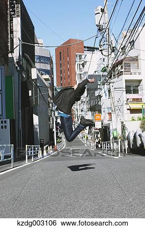 Stock Photograph - Young man jumping in an alley. Fotosearch