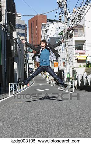 Stock Photography - Young man jumping in an alley. Fotosearch