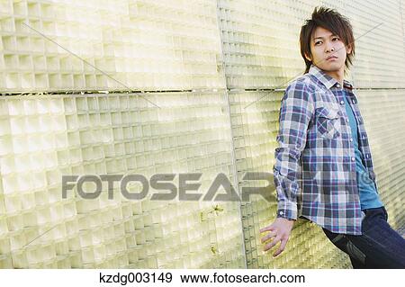 Young man leaning against a wall View Large Photo Image Stock Photo - Young man leaning against a wall. Fotosearch