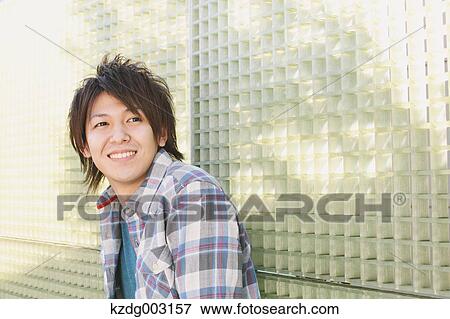 Young man leaning against a wall View Large Photo Image Stock Photo - Young man leaning against a wall. Fotosearch