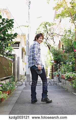 Stock Image - Young man looking at camera. Fotosearch