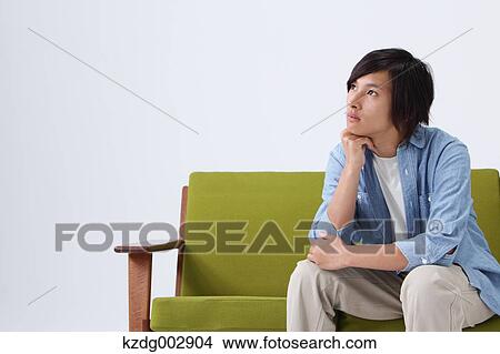 Picture - Young man on the sofa. Fotosearch