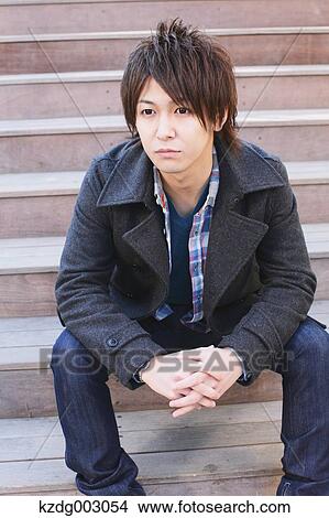 Picture - Young man sitting on the stairs. Fotosearch