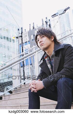 Young man sitting on the stairs View Large Photo Image Stock Image - Young man sitting on the stairs. Fotosearch