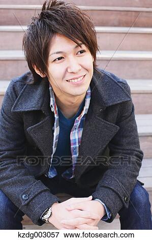 Stock Photo - Young man sitting on the stairs. Fotosearch