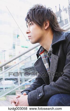 Stock Photo - Young man sitting on the stairs. Fotosearch