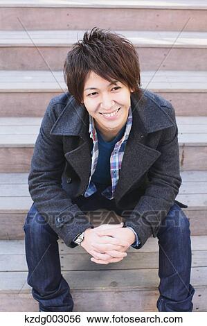 Stock Photograph - Young man sitting on the stairs. Fotosearch