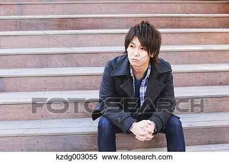 Young man sitting on the stairs View Large Photo Image Stock Photography - Young man sitting on the stairs. Fotosearch