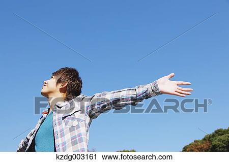 Stock Image - Young man spreading arms. Fotosearch