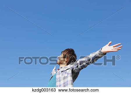 Stock Image - Young man spreading arms. Fotosearch