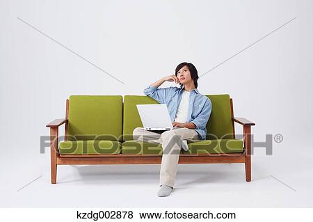 Young man with laptop on the sofa View Large Photo Image Stock Photo - Young man with laptop on the sofa. Fotosearch