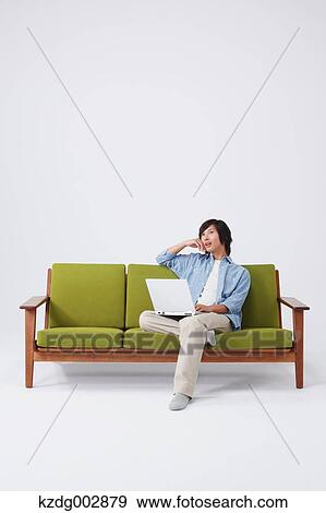 Young man with laptop on the sofa View Large Photo Image Stock Photo - Young man with laptop on the sofa. Fotosearch