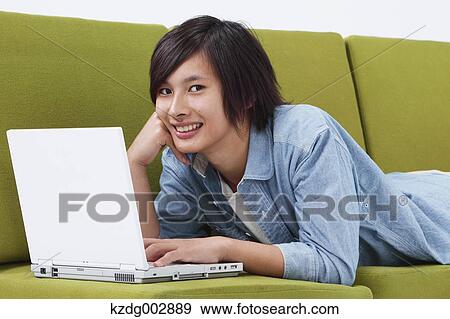 Young man with laptop on the sofa View Large Photo Image Stock Photo - Young man with laptop on the sofa. Fotosearch