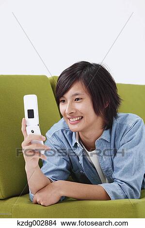 Young man with phone on the sofa View Large Photo Image Picture - Young man with phone on the sofa. Fotosearch