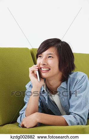 Young man with phone on the sofa View Large Photo Image Stock Image - Young man with phone on the sofa. Fotosearch
