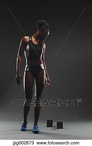 Stock Image - African Female Athlete Exercising, Studio Shot. Fotosearch