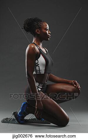 Stock Photograph - African Woman Runner at Starting Block. Fotosearch
