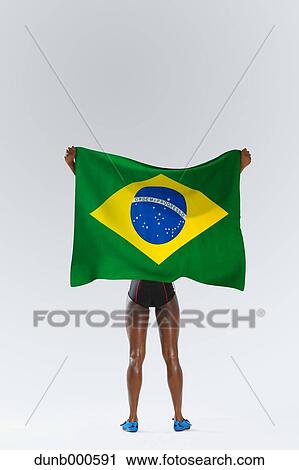 Stock Image - Female Athlete Holding a Brazilian Flag. Fotosearch