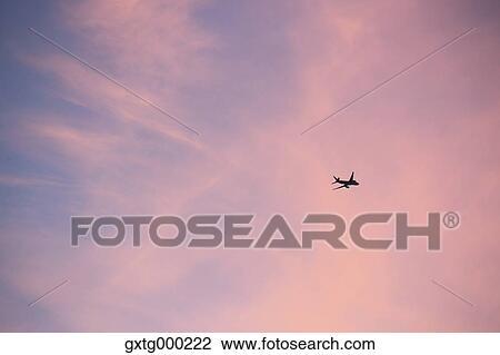 Stock Image - Airplane flying in the sky. Fotosearch