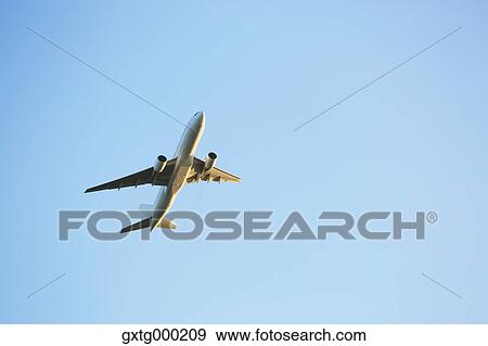 Stock Photo - Airplane flying in the sky. Fotosearch