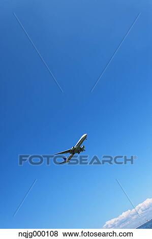 Stock Photo - Airplane flying in the sky. Fotosearch