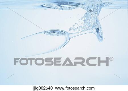 Stock Image - Champagne glass falling into water. Fotosearch